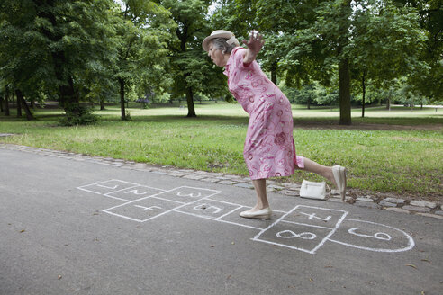 Senior woman playing hopscotch - FSIF02879