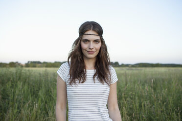 Profil eines Mädchens mit Haarband, das in einem abgelegenen Feld steht - FSIF02908