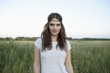 Profile of girl with hair band standing in secluded field - FSIF02908