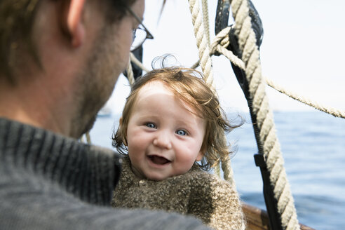 Ein aufgeregtes Baby mit seinem Vater auf einem Boot - FSIF02916