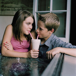 Ein junges Paar im Teenageralter trinkt einen Milchshake in einem Diner - FSIF02939
