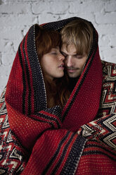 Ein sinnliches junges Paar, eingewickelt in eine Decke - FSIF02966