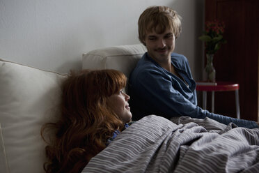 Ein junges Paar entspannt sich Seite an Seite im Bett - FSIF02973