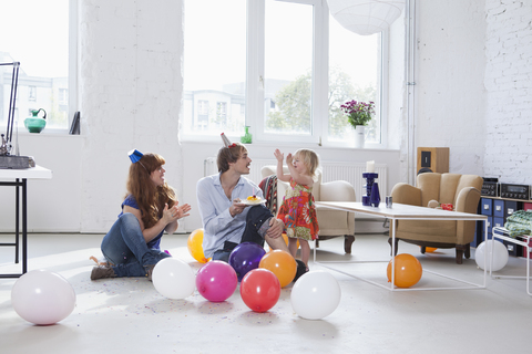 Eine junge Familie feiert den Geburtstag ihrer Tochter, lizenzfreies Stockfoto