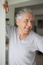 Ein fröhlicher älterer Mann steht in einer Tür - FSIF02987