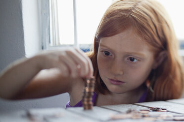 Girl stacking coins - FSIF02992