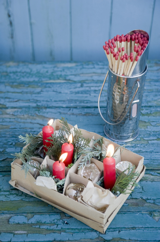 Karton mit alten Weihnachtskugeln und roten Kerzen, Streichhölzer, lizenzfreies Stockfoto