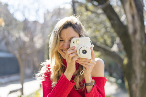 Happy young woman taking a picture in a garden stock photo