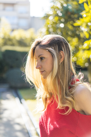 Porträt einer attraktiven jungen Frau in einem Garten, lizenzfreies Stockfoto