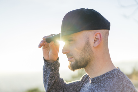 Young man wearing a cap in backlight stock photo