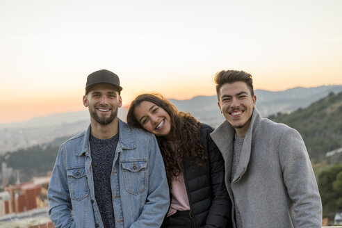 Portrait of three happy friends on a hill at sunset - AFVF00224