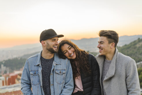Portrait of three happy friends on a hill at sunset - AFVF00225