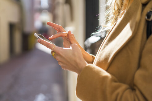 Nahaufnahme einer jungen Frau in einer Fahrspur, die ein Mobiltelefon benutzt - AFVF00231