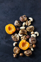 Sliced apricot, dried figs, almonds and various nuts on dark ground - CSF28937