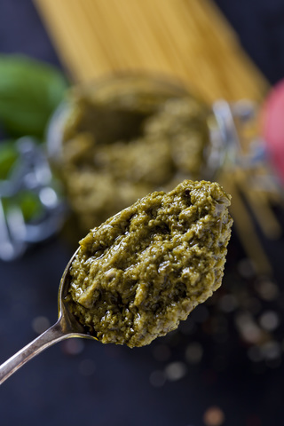 Spoon of basil pesto, close-up stock photo