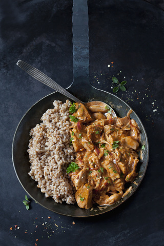 Jackfruit goulash with spelt rice in pan stock photo