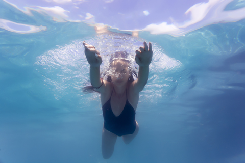 Young woman underwater in a swimming pool stock photo
