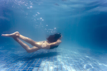 Junge Frau unter Wasser in einem Schwimmbad - KNTF00987