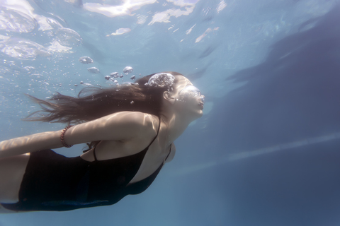 Young woman underwater in a swimming pool stock photo