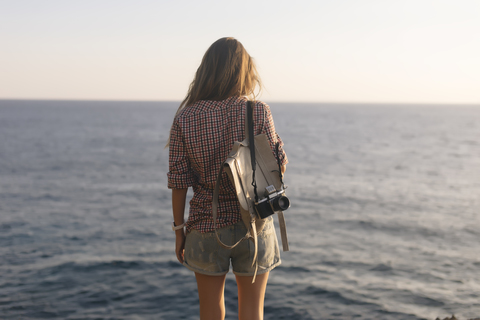 Indonesia, Bali, Lembongan island, young woman with camera at ocean coastline stock photo