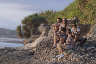 Indonesien, Bali, Insel Lembongan, Freunde bei einem Drink an der Meeresküste - KNTF01007