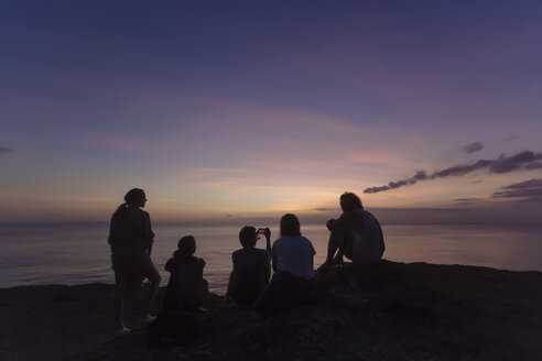 Indonesien, Bali, Insel Lembongan, Freunde an der Meeresküste in der Abenddämmerung - KNTF01010