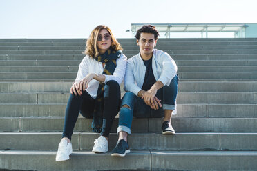 Portrait of stylish young couple sitting on stairs outdoors - AFVF00255