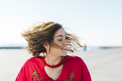 Happy young woman outdoors shaking her hair stock photo