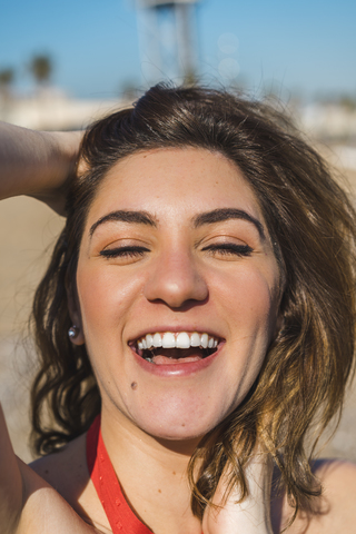 Portrait of laughing young woman on the beach stock photo