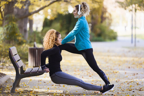 Zwei sportliche junge Frauen beim Stretching im Park - JSRF00018