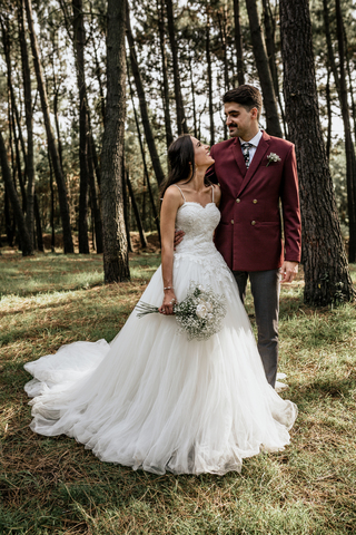 Glückliche Braut und Bräutigam stehen im Wald, lizenzfreies Stockfoto