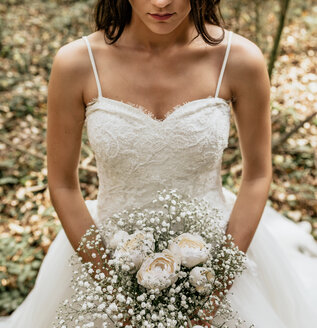 Nahaufnahme einer Braut mit Blumenstrauß im Wald - DAPF00904