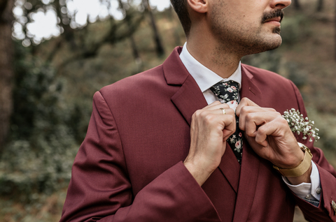 Close-up of man wearing a suit in forest adjusting his tie stock photo