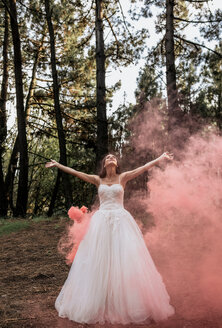 Frau im Hochzeitskleid im Wald, umgeben von Rauchwolken - DAPF00921