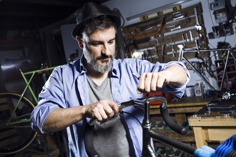 Man working on bicycle in workshop stock photo