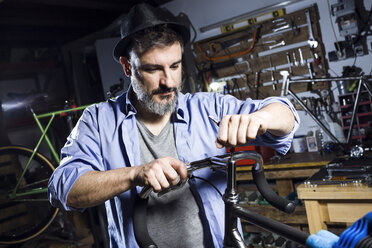 Man working on bicycle in workshop - JSRF00023