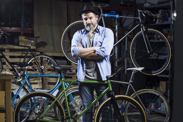 Portrait of confident man in bicycle workshop - JSRF00025