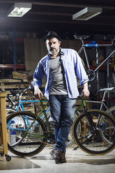 Porträt eines selbstbewussten Mannes in einer Fahrradwerkstatt - JSRF00026