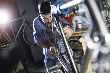 Mann arbeitet in einer Werkstatt an einem Fahrrad - JSRF00027