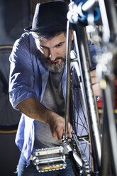 Mann arbeitet in einer Werkstatt an einem Fahrrad - JSRF00028