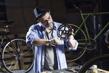 Mann arbeitet an einem Pedal in einer Fahrradwerkstatt - JSRF00029