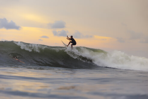 Indonesien, Bali, Surfer beim Surfen auf der Welle - KNTF01013