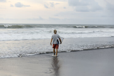 Indonesia, Bali, surfer walking into water - KNTF01017