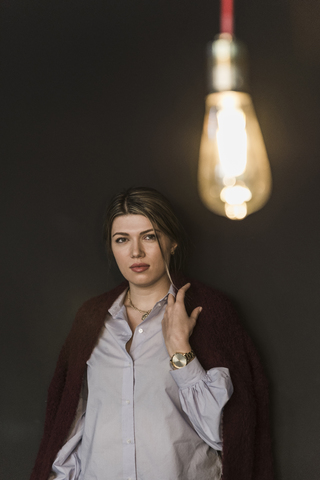 Junge Frau mit beleuchteter Glühbirne, lizenzfreies Stockfoto