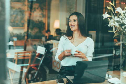 Portrait of laughing young woman waiting in a coffee shop stock photo