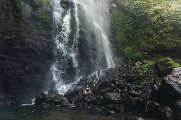 Indonesien, Bali, junge Frau übt Yoga am Sekumpul-Wasserfall - KNTF01034