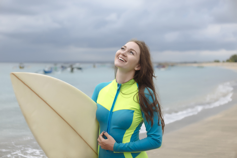 Indonesien, Bali, junge Frau mit Surfbrett, lizenzfreies Stockfoto