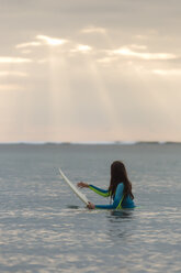 Indonesia, Bali, young woman with surf board in water - KNTF01043