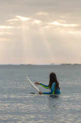 Indonesien, Bali, junge Frau mit Surfbrett im Wasser - KNTF01043
