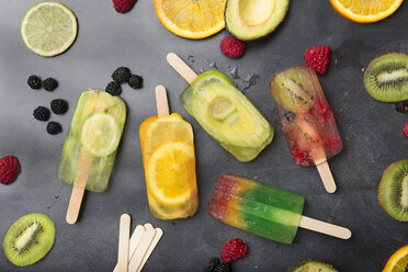 Various fruit popsicles and fruits on grey background - SKCF00339